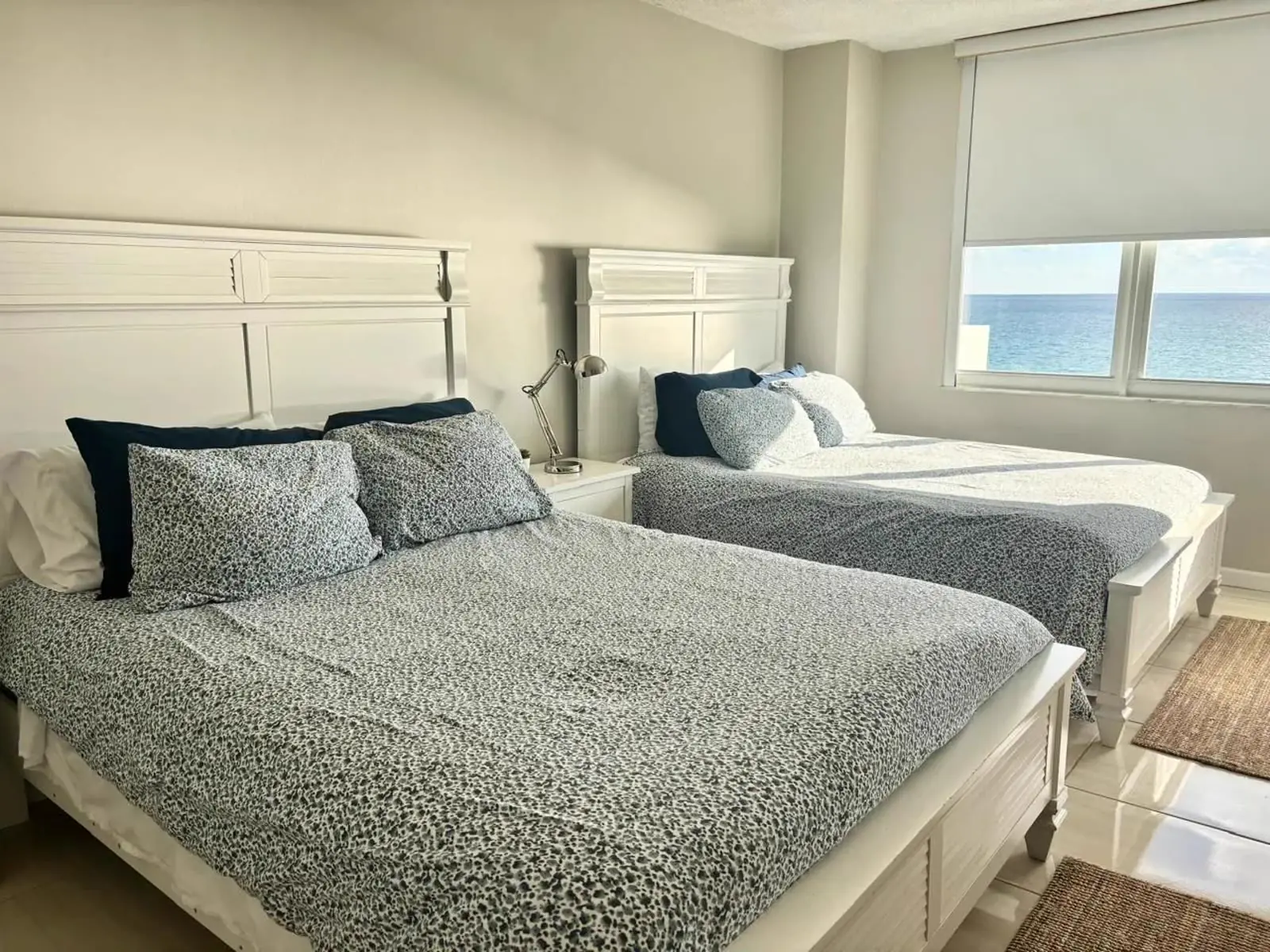 Dormitorio con dos camas y ventana al mar