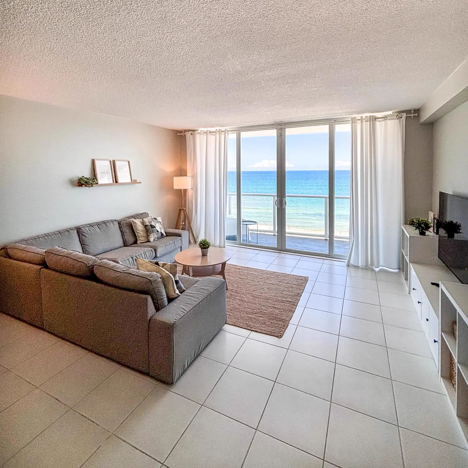 Living con ventanal al mar, departamento de tres dormitorios